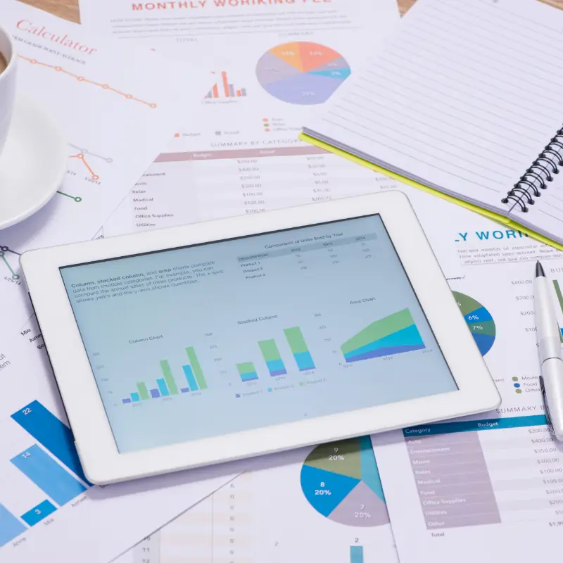 Stack of business graphs with ipad on top