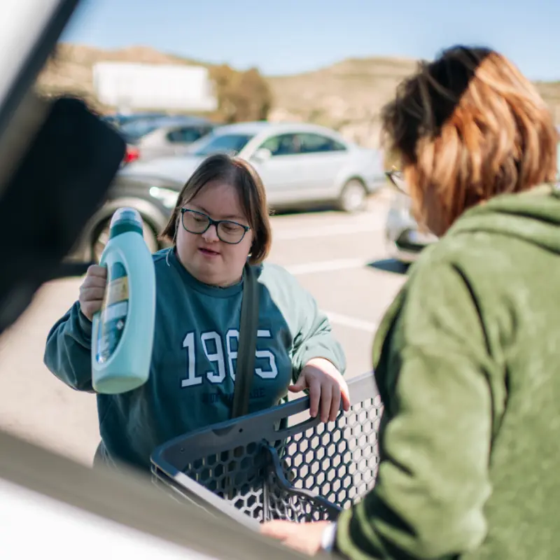 Woman with down syndrome putting detergent in car